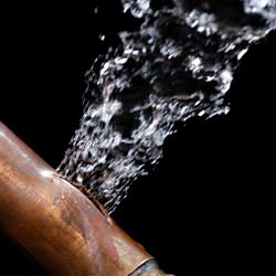 A bursting copper pipe in Laurel, with water gushing out.