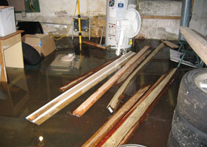 A severely flooding basement in Columbus, with lumber and personal items floating in a foot of water