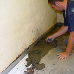 A basement waterproofer installing a perimeter drain system in White Sulphur Springs