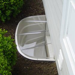 A vinyl basement window and covered window well in Ashland