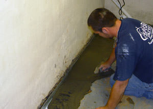 Restoring a concrete slab floor with fresh concrete after jackhammering it and installing a drain system in Hays.