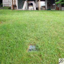 A buried sump pump discharge line in a yard in Crow Agency