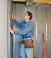 Insulated basement wall panels being placed against a concrete foundation wall in Red Lodge